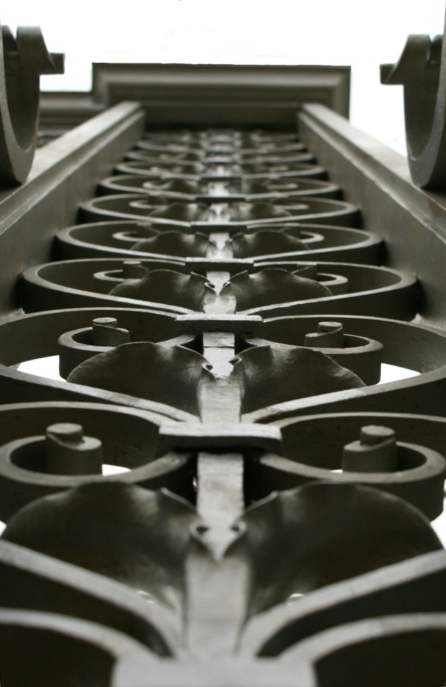 Gate piers scrolls, leaves and collars.